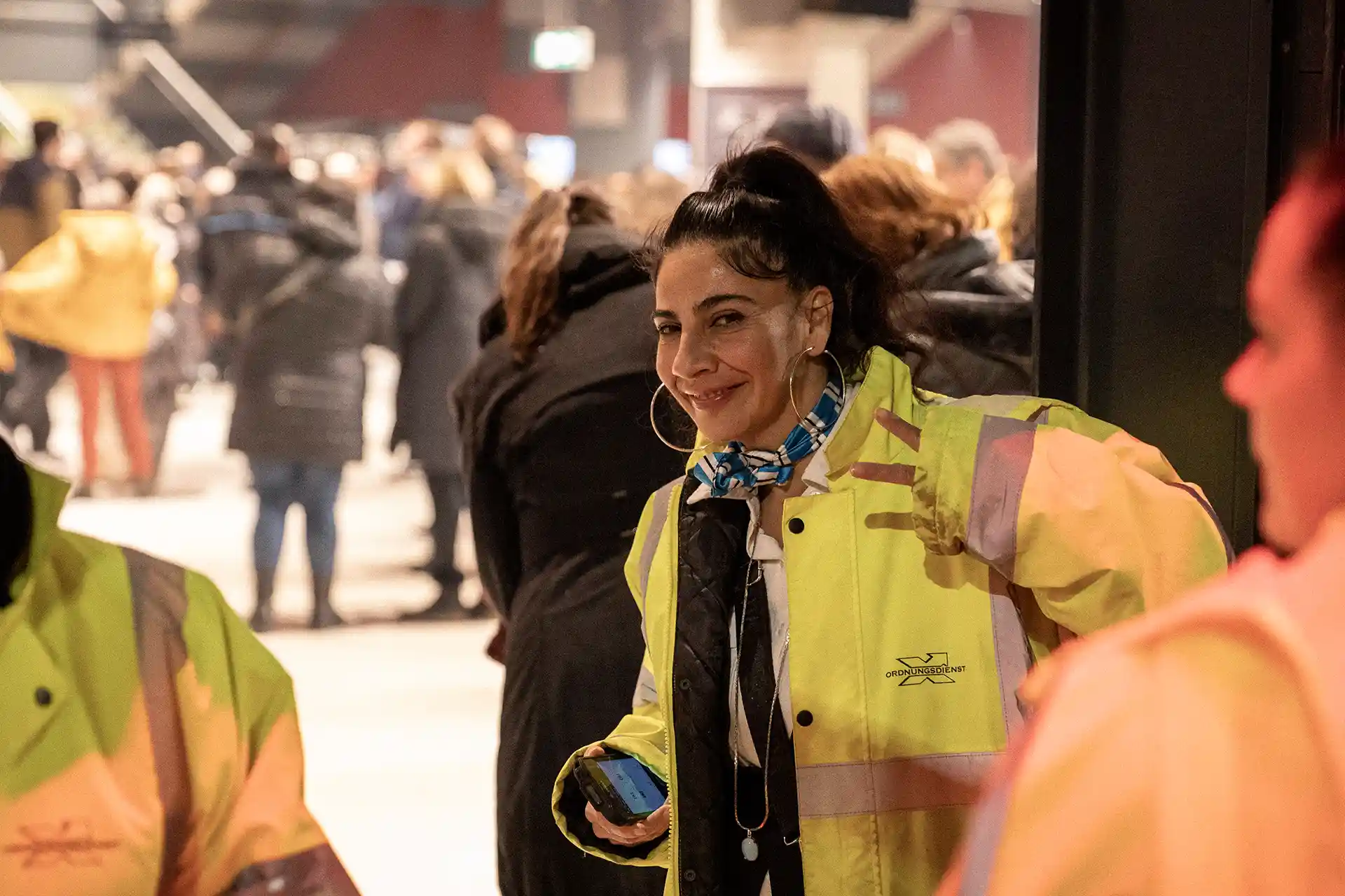 Mitarbeiterin von Special Security Services grüßt freundlich in die Kamera